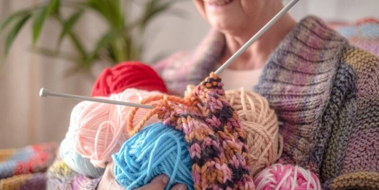 Elderly Woman Knitting with Colorful Yarn at Assisted Living Facility