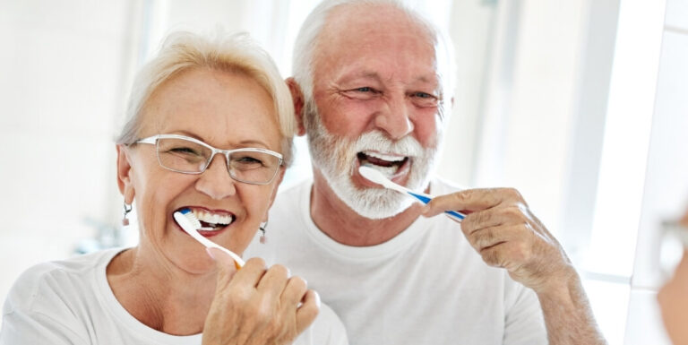 Elderly Couple Brushing Teeth Together to Maintain Dental Hygiene at Memory Care Facility