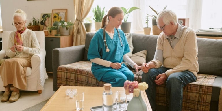 Female Nurse Checking Blood Pressure of Memory Care Facility Resident